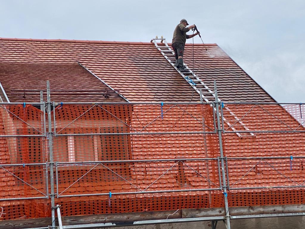 homme en plein nettoyage de toiture sur Vaud