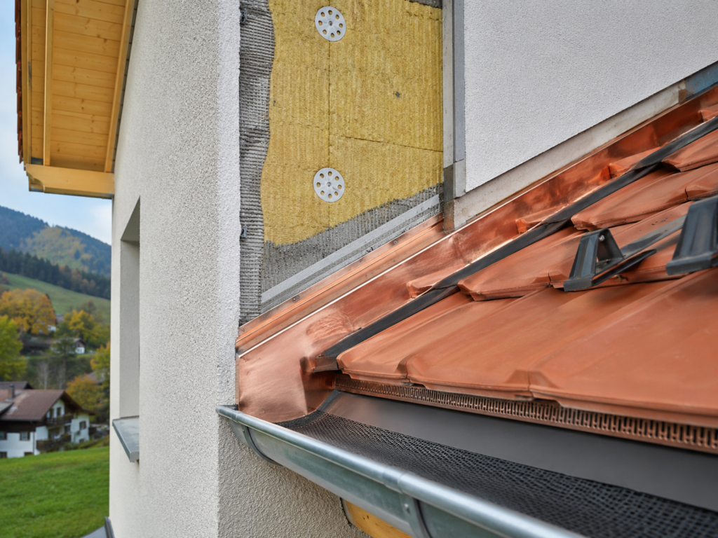 Jonction entre isolation de toiture et façade sur une maison vaudoise
